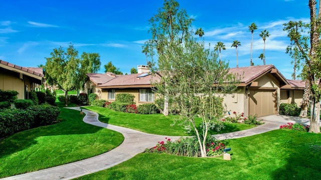 single story home featuring a garage and a front lawn