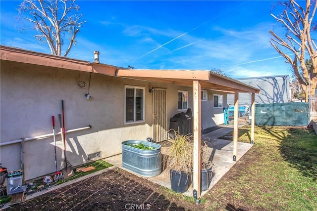 rear view of house featuring a patio area and a lawn