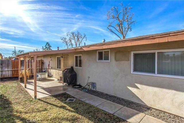 back of house featuring a patio area and a lawn