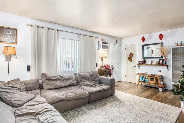 living room featuring a wall mounted air conditioner and hardwood / wood-style flooring