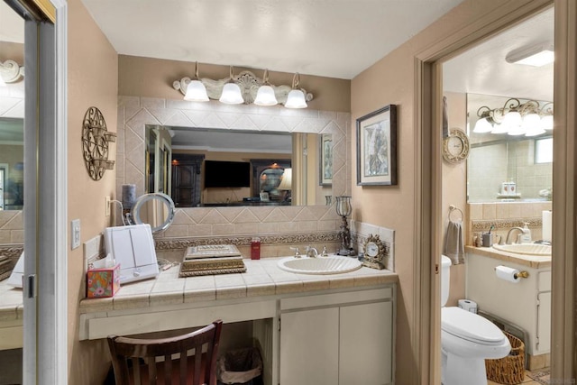 bathroom featuring toilet, tasteful backsplash, and vanity