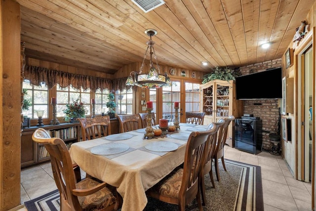 dining area featuring light tile patterned floors and wood ceiling