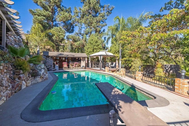 view of pool with a gazebo, a diving board, and a patio