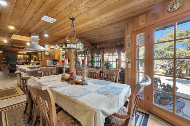 dining space featuring light tile patterned floors and wood ceiling