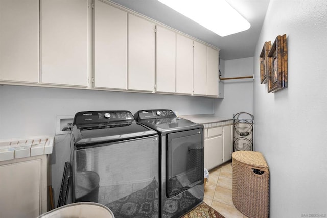 laundry room featuring light tile patterned flooring, independent washer and dryer, and cabinets