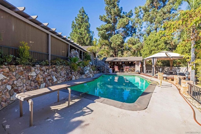 view of pool with a gazebo, a patio area, and a diving board