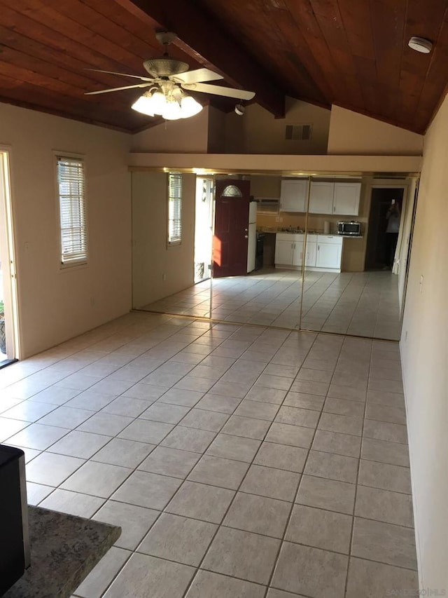 tiled empty room featuring wooden ceiling, lofted ceiling with beams, and ceiling fan