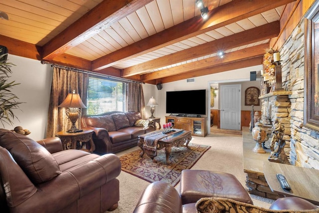 carpeted living room with vaulted ceiling with beams, wood ceiling, and a stone fireplace