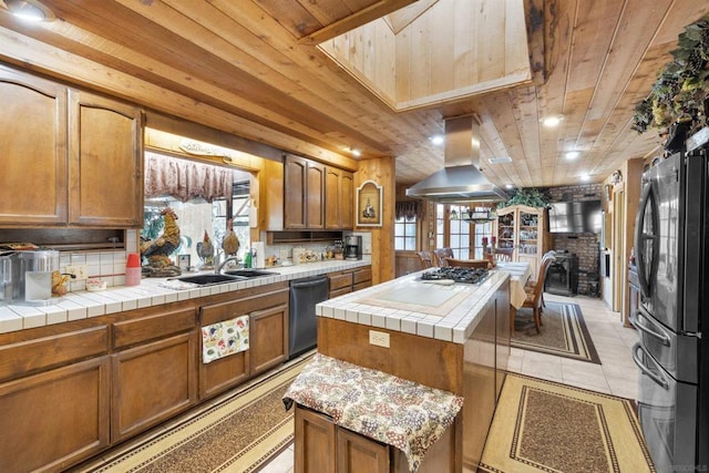 kitchen with a center island, wood ceiling, island exhaust hood, stainless steel appliances, and tile countertops