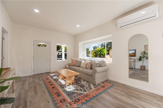 living room featuring a wall mounted AC and light wood-type flooring