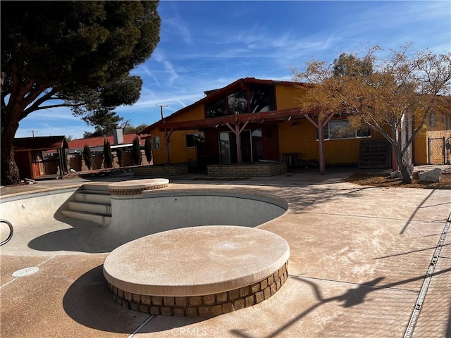 rear view of house featuring a patio and fence