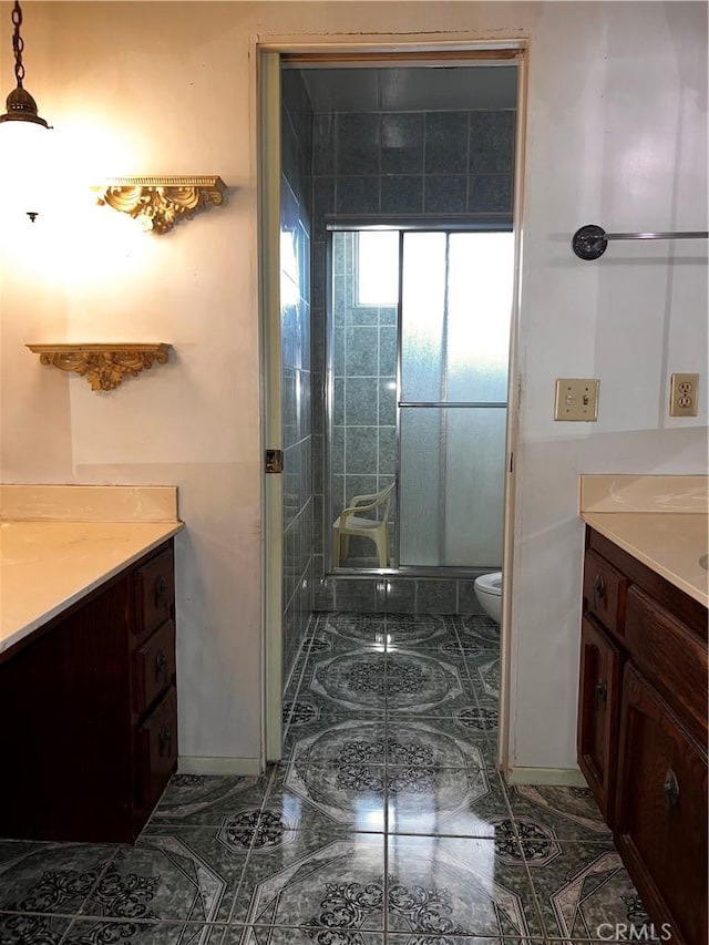 full bathroom featuring toilet, a stall shower, and vanity