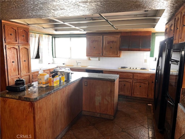 kitchen featuring white electric stovetop, brown cabinetry, and dark countertops