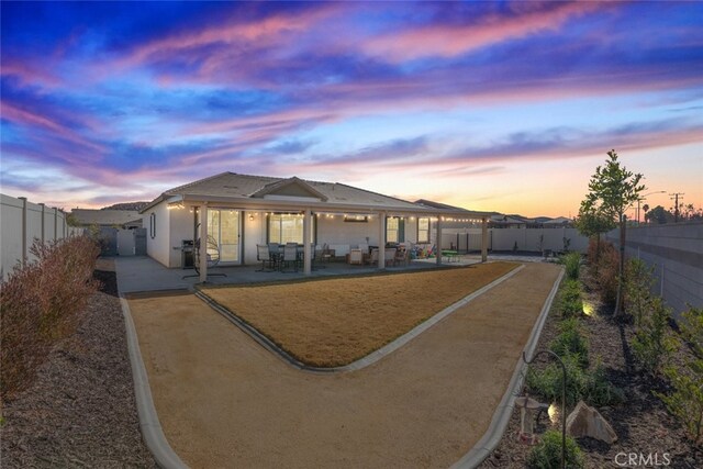 back house at dusk with a patio