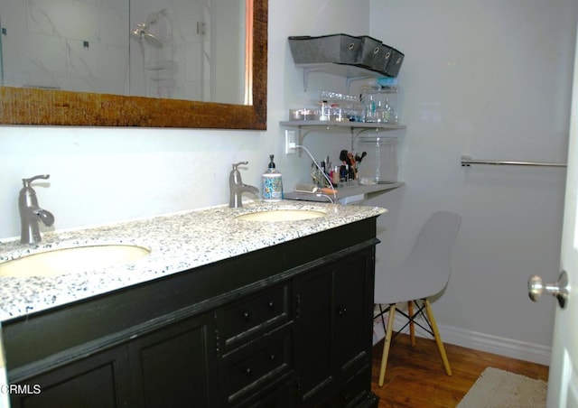 bathroom featuring hardwood / wood-style flooring, a shower, and vanity