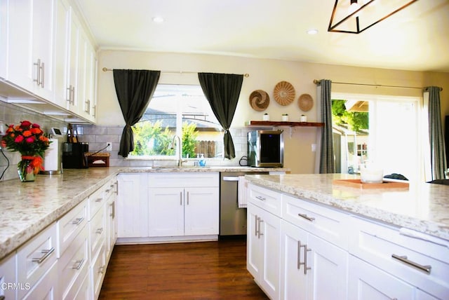 kitchen featuring sink, stainless steel dishwasher, white cabinets, and light stone countertops