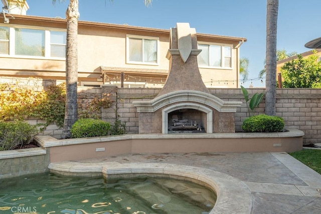 view of patio / terrace featuring exterior fireplace