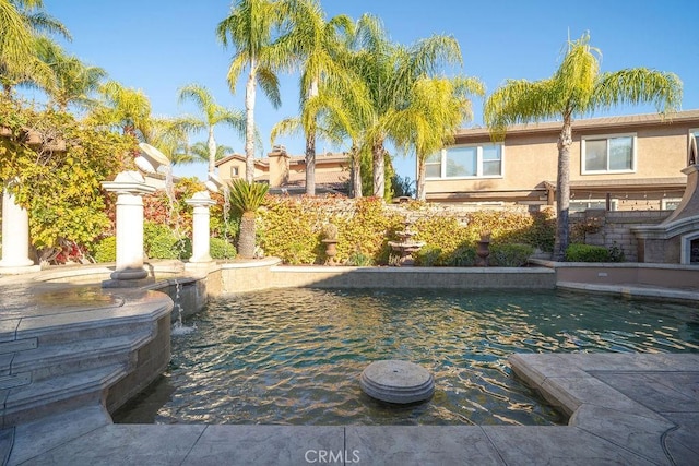 view of swimming pool with pool water feature