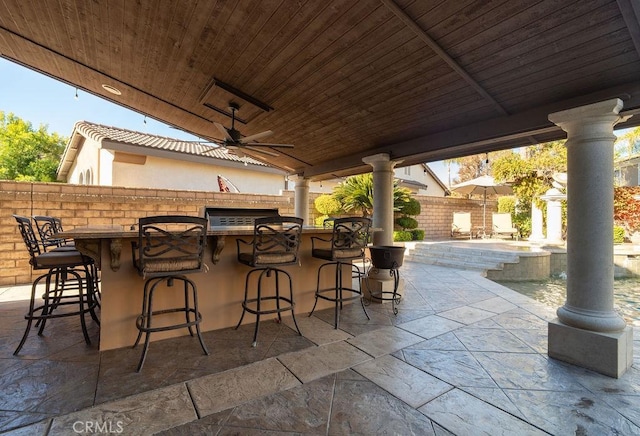 view of patio / terrace with ceiling fan and an outdoor bar