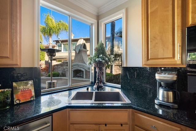 kitchen featuring sink, dishwasher, crown molding, and dark stone counters