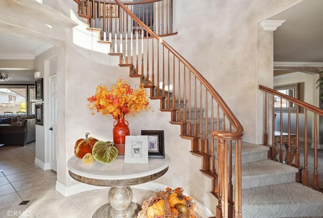 staircase with a high ceiling, tile patterned floors, and crown molding