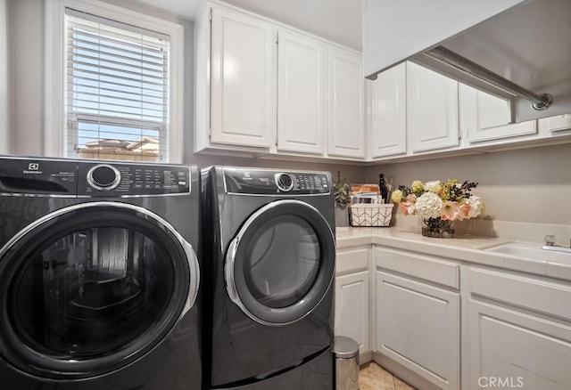 washroom featuring sink, independent washer and dryer, and cabinets