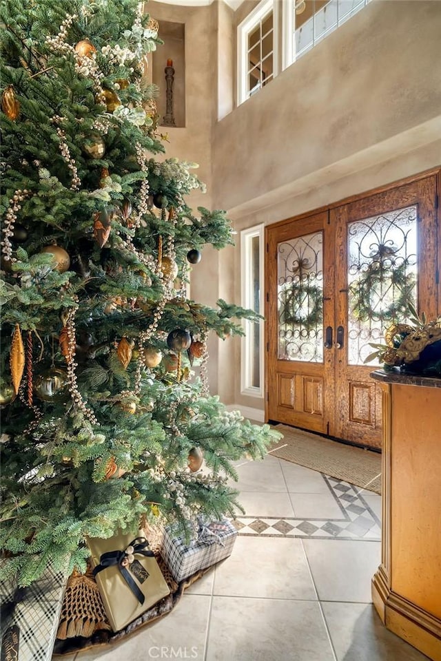 entrance foyer featuring light tile patterned floors, a healthy amount of sunlight, and french doors