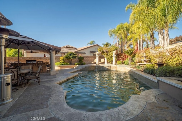 view of pool with ceiling fan, an outdoor bar, and a patio