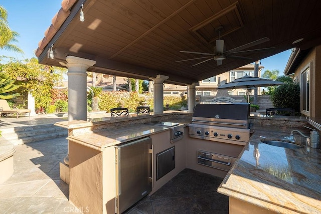 view of patio / terrace with ceiling fan, a grill, exterior kitchen, and sink