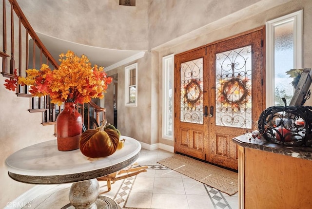 entrance foyer with light tile patterned floors, french doors, and a healthy amount of sunlight