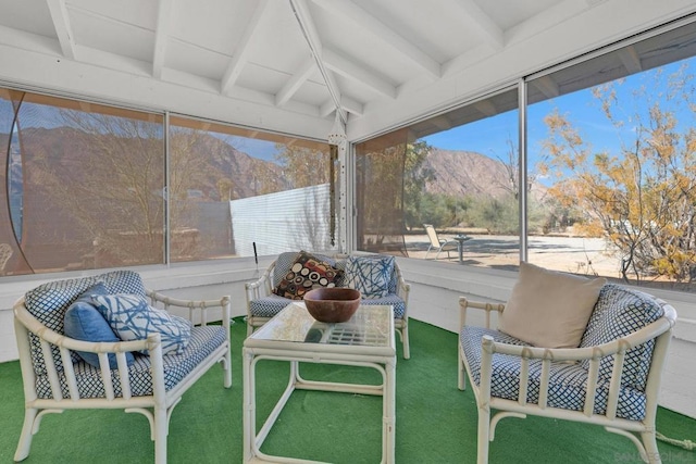 sunroom with lofted ceiling with beams and a mountain view