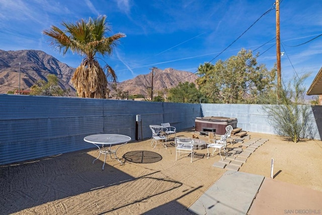 view of patio / terrace with a hot tub and a mountain view