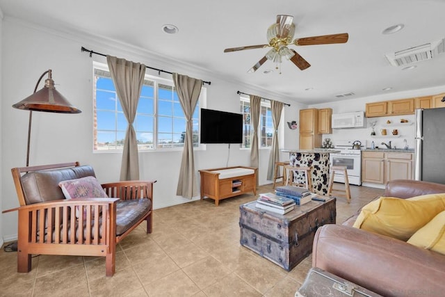 tiled living room with ceiling fan, sink, and crown molding