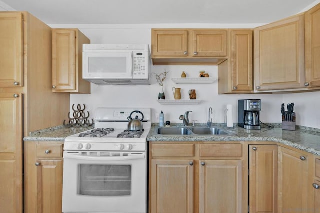 kitchen with light brown cabinetry, light stone countertops, sink, and white appliances