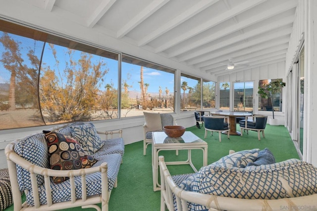 sunroom featuring vaulted ceiling with beams