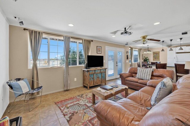 living room with ceiling fan, light tile patterned floors, crown molding, and french doors