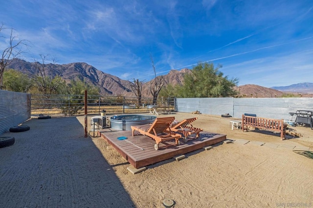 view of yard with a mountain view and a hot tub