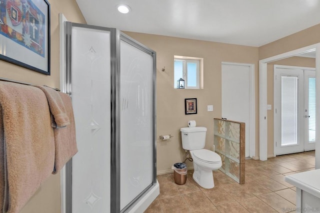 bathroom featuring toilet, tile patterned floors, plenty of natural light, and walk in shower