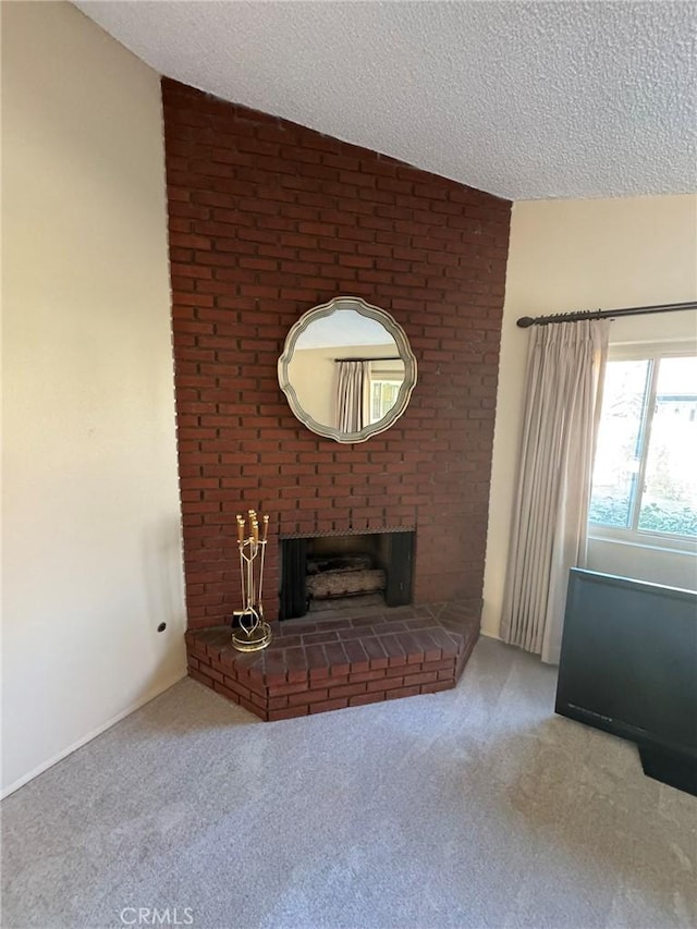 unfurnished living room with lofted ceiling, carpet, a brick fireplace, and a textured ceiling