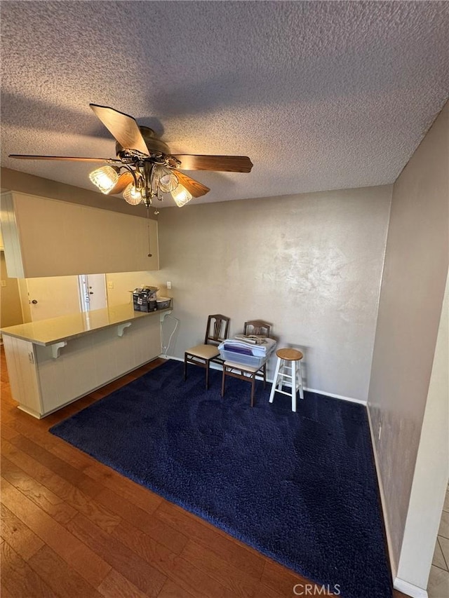 sitting room featuring a textured ceiling, ceiling fan, and hardwood / wood-style floors