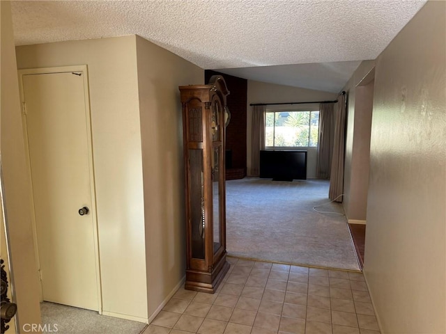 hallway with a textured ceiling, vaulted ceiling, and light colored carpet