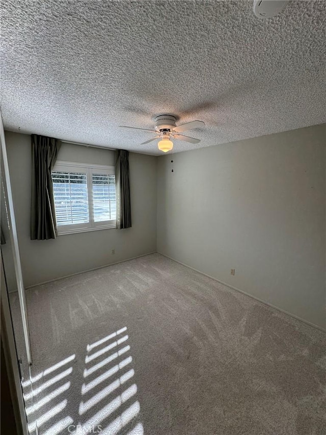 empty room with a textured ceiling and carpet flooring