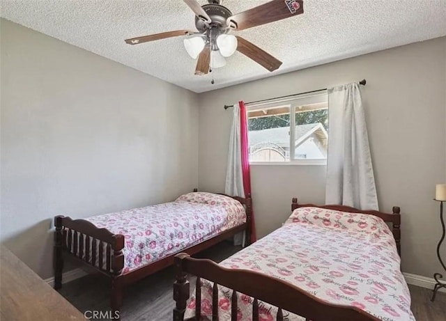 bedroom featuring ceiling fan, a textured ceiling, and dark hardwood / wood-style flooring