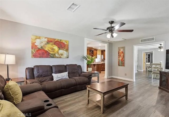 living room with ceiling fan and hardwood / wood-style floors