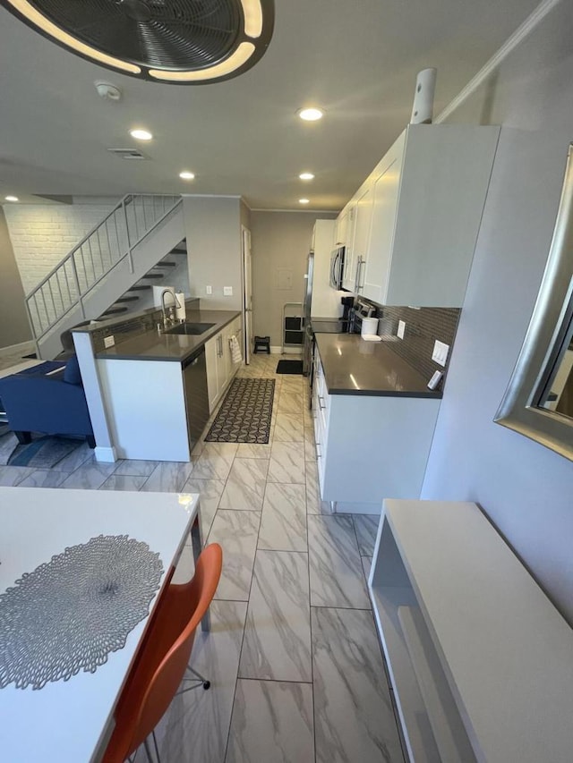 kitchen with appliances with stainless steel finishes, white cabinets, and sink