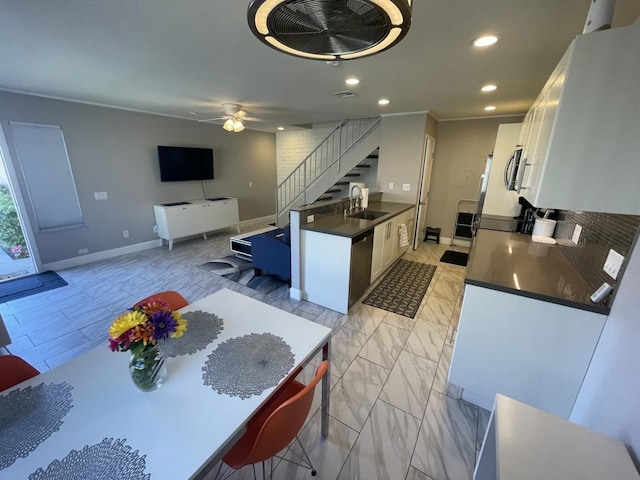 kitchen with ceiling fan, stainless steel dishwasher, white cabinets, and sink