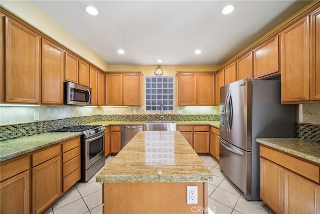 kitchen with sink, light tile patterned floors, tasteful backsplash, a kitchen island, and stainless steel appliances