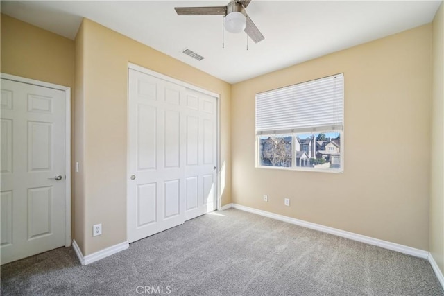 unfurnished bedroom with ceiling fan, carpet floors, and a closet