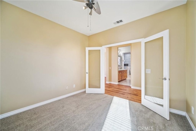 unfurnished bedroom featuring ceiling fan, light colored carpet, and french doors