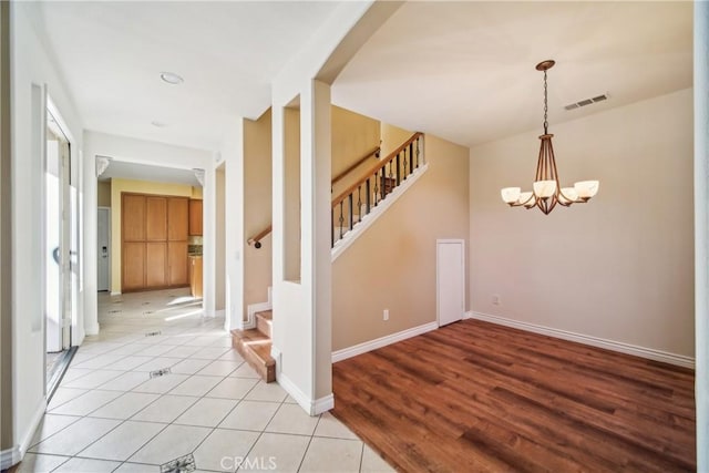 tiled entryway featuring a notable chandelier